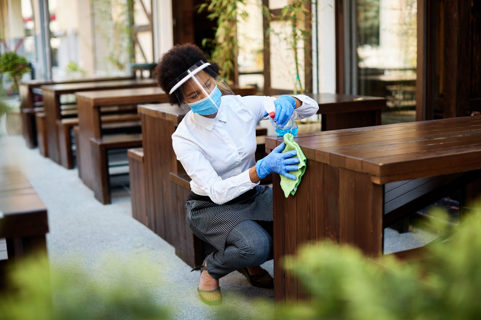 Cafe owner cleaning tables with disinfectant while reopening dur Cleaner Reddford House Blue Hills 2025