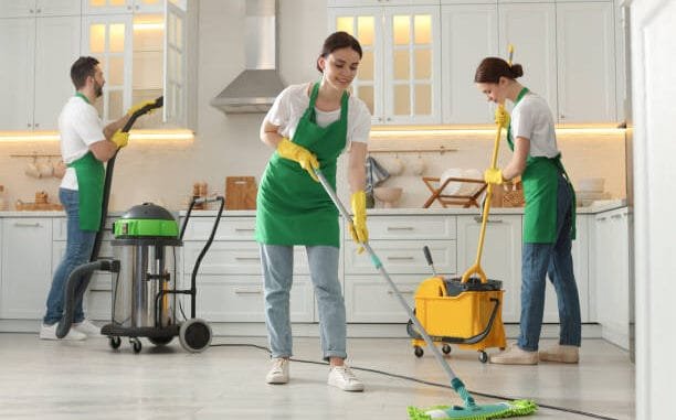 Team of professional janitors working in kitchen